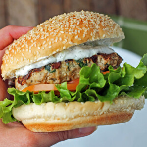 Hand golding a Greek turkey burger