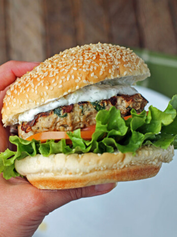 Hand golding a Greek turkey burger