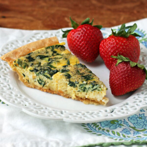 Spinach Feta Quiche slice plated with strawberries