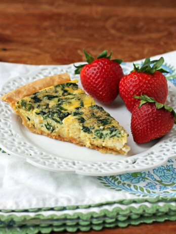 Spinach Feta Quiche slice plated with strawberries