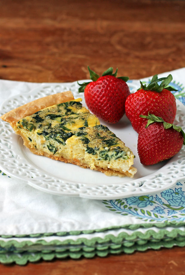 Spinach Feta Quiche slice plated with strawberries