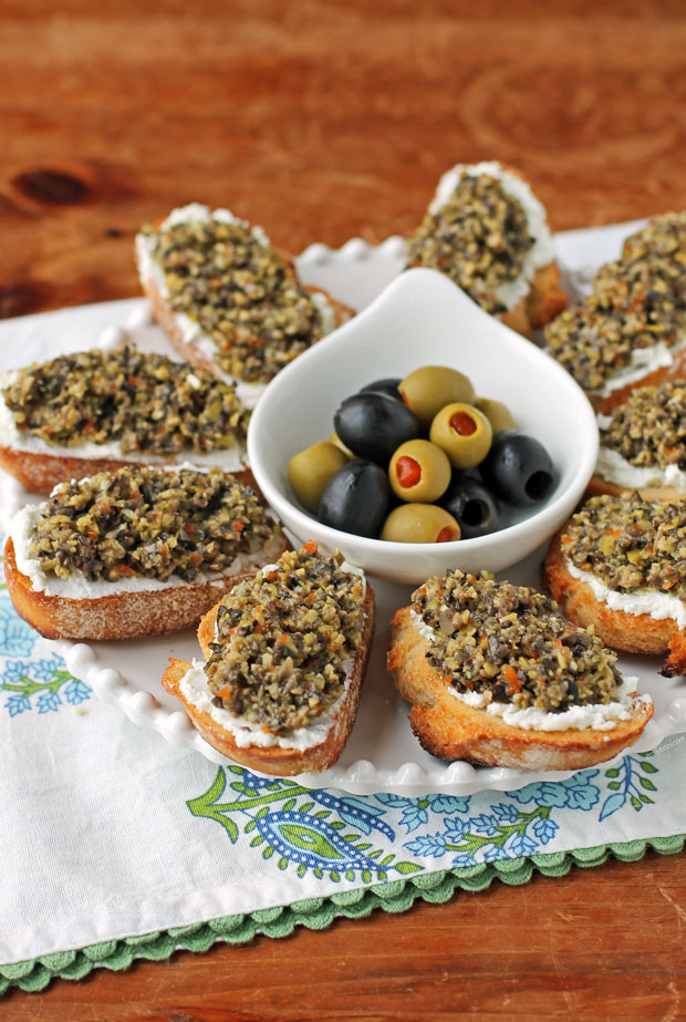 Olive Tapenade Goat Cheese Crostini on a platter with olives
