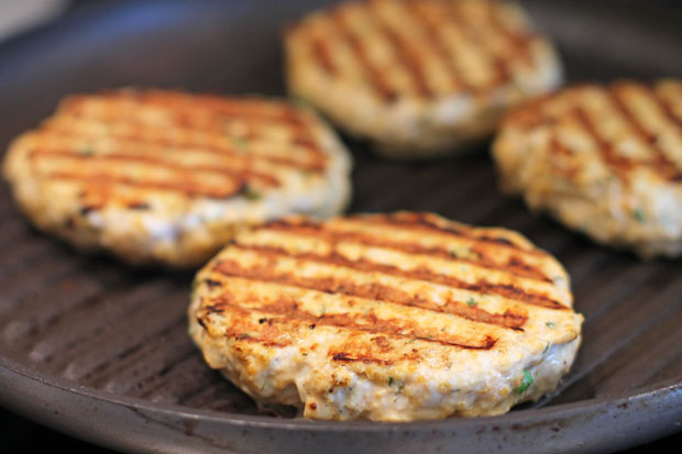 Buffalo Chicken Burgers patties cooking on a pan