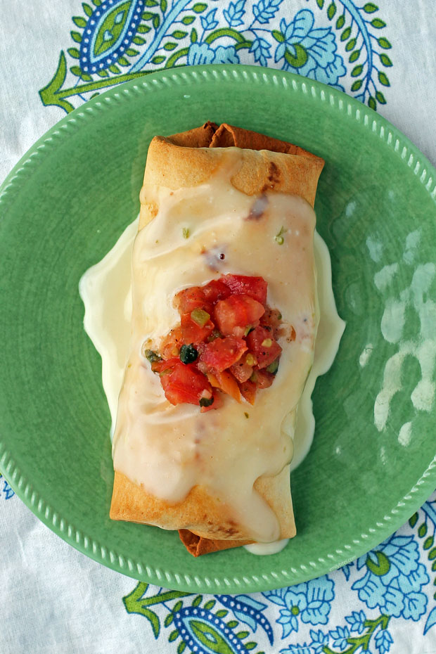 Beef and Bean Chimichanga with queso on a plate