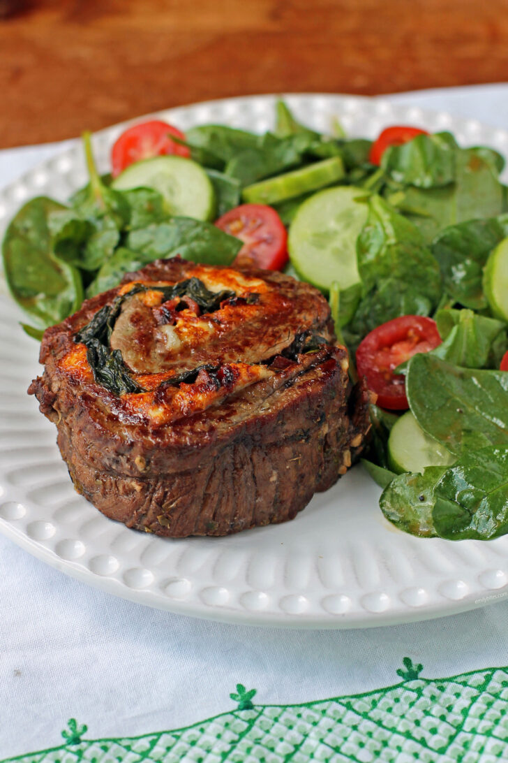 Stuffed Balsamic Flank Steak Pinwheel plated with salad