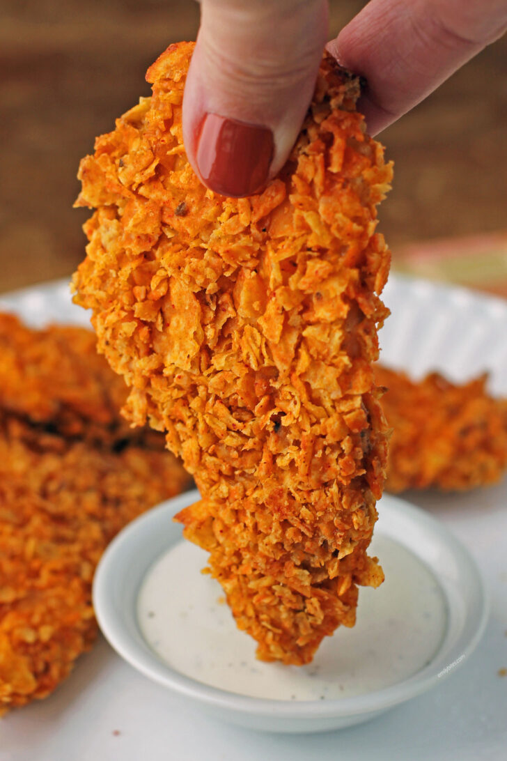 Doritos-Crusted Chicken Tender getting dipped into ranch dressing