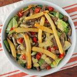 Pittsburgh Steak Salad with Warm Riviera Dressing mixed in a bowl