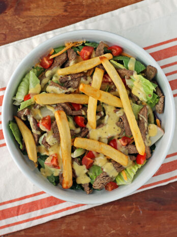 Pittsburgh Steak Salad with Warm Riviera Dressing mixed in a bowl