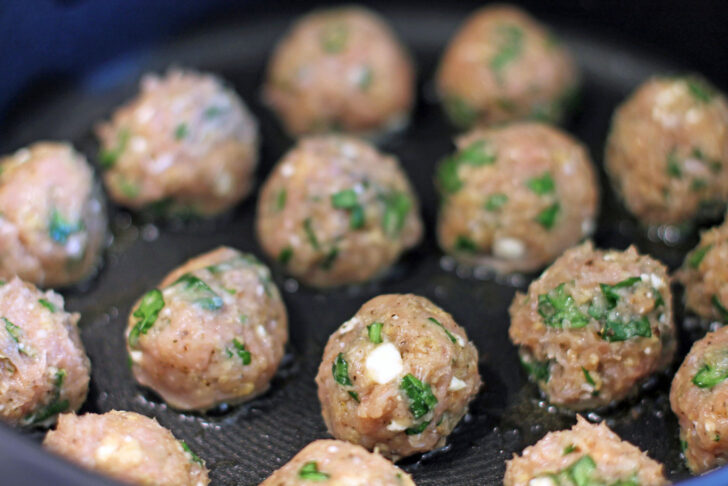 Greek Chicken Meatballs uncooked in the pan