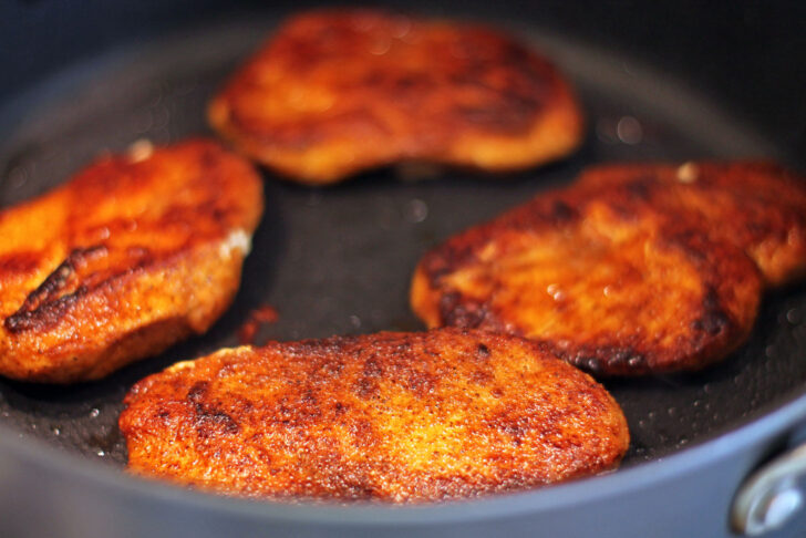 Buffalo Chicken cutlets cooking in a pan