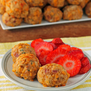 Maple Bacon Bisquick Sausage Balls plated with strawberries